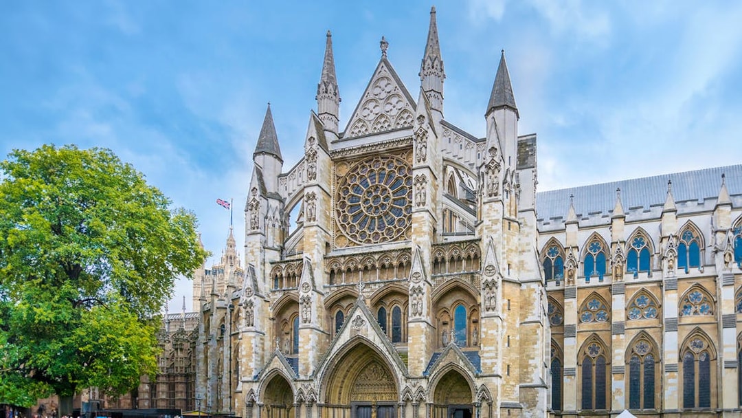 Westminster Abbey facade with visitors, London.