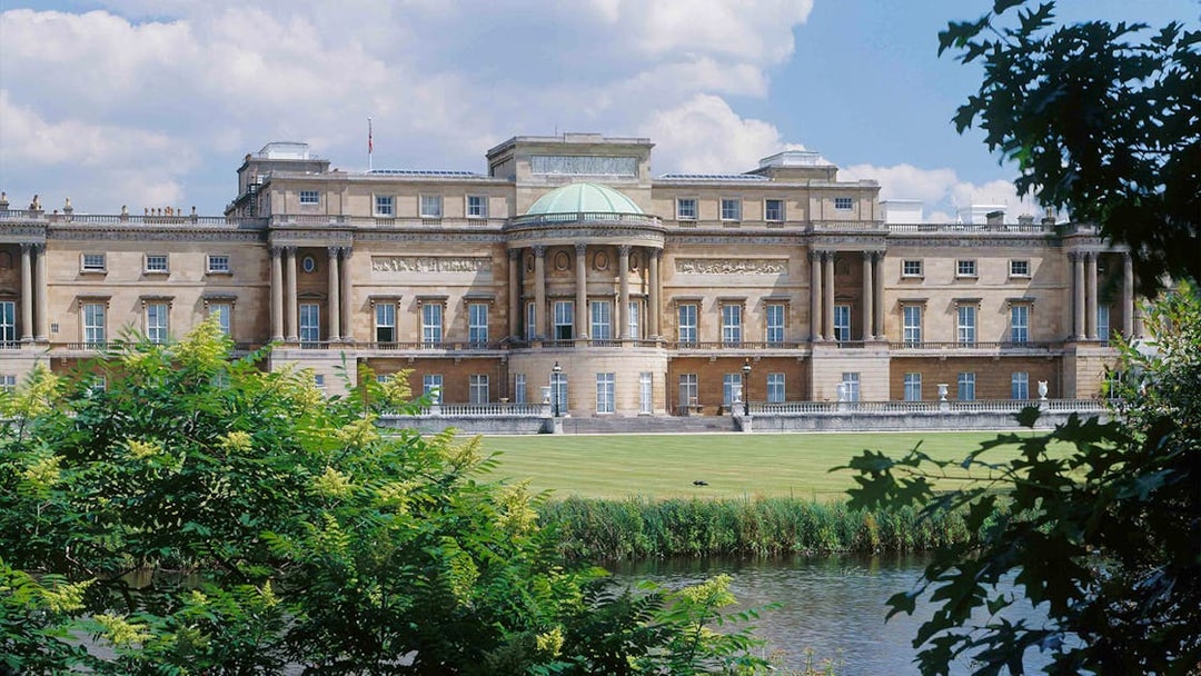 Buckingham Palace viewed from the garden with a pond in the foreground.