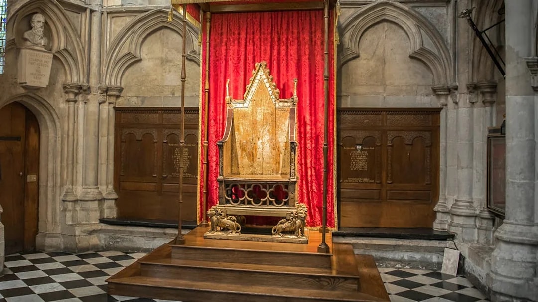 Coronation Chair at Westminster Abbey with red drapery backdrop.