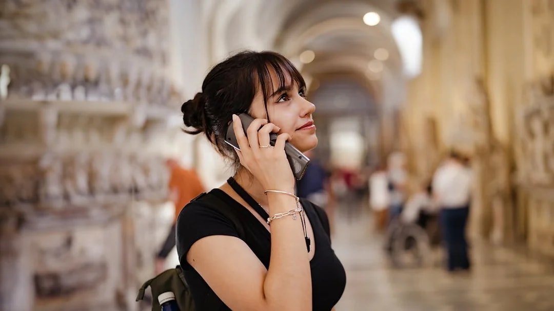 Visitor using an audio guide inside a historic building, related to Westminster Abbey and Tower of London tour.