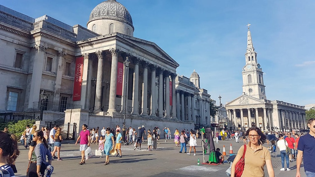 National Gallery and St Martin-in-the-Fields church in London with tourists exploring the area.