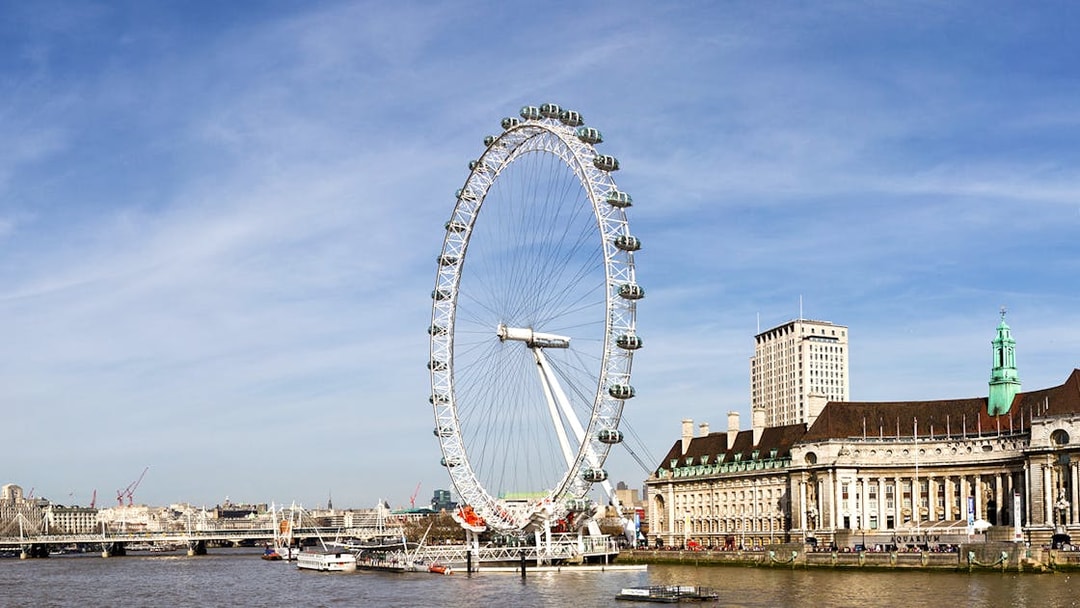 London Eye overlooking the Thames River with cityscape in the background.