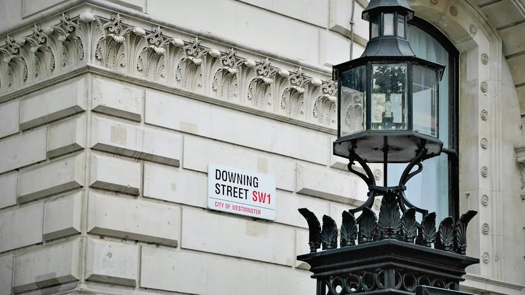Downing Street sign and ornate lamp post in Westminster, London.