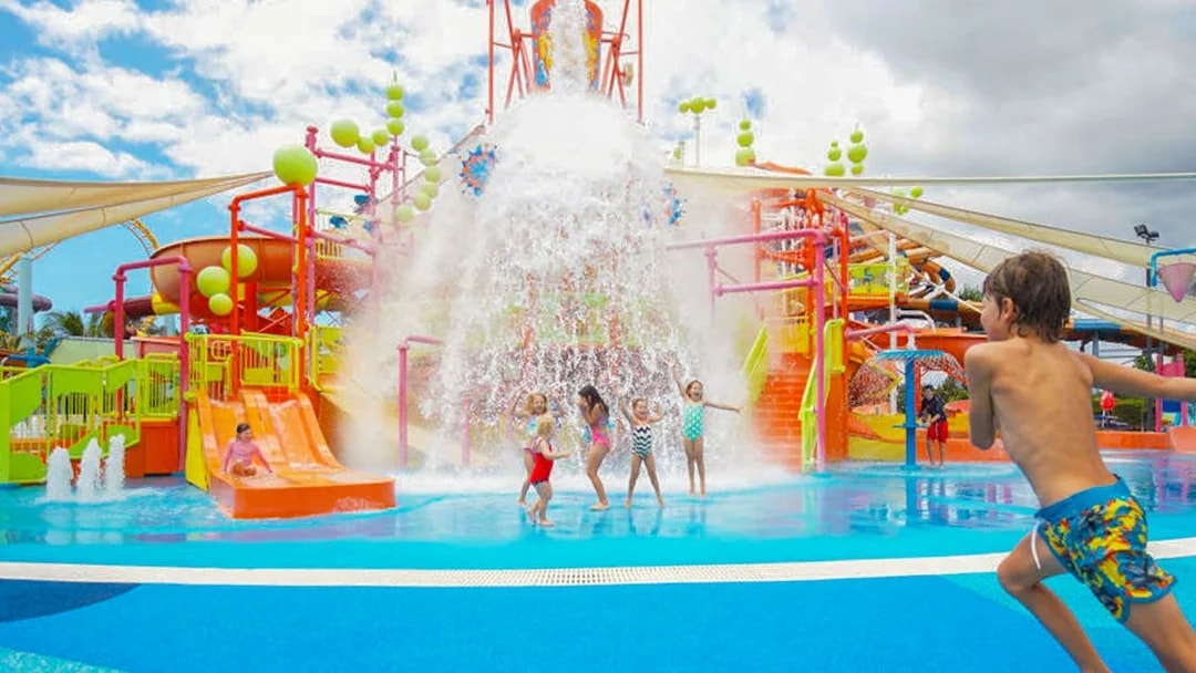 Children playing under water bucket at WhiteWater World, Gold Coast.