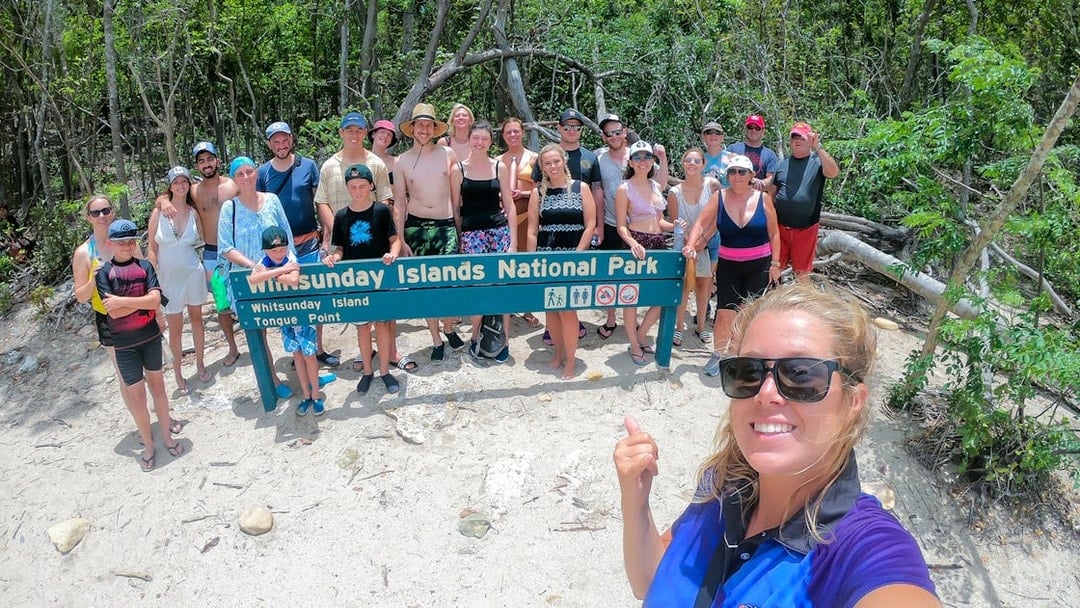 Group at Whitsunday Islands National Park sign during Fly + Raft tour.