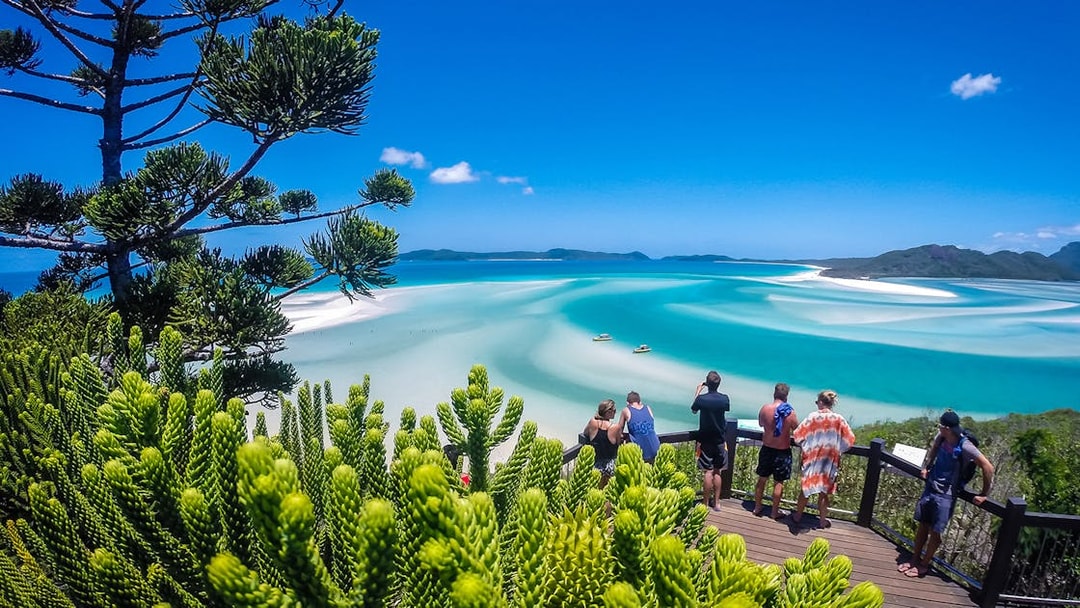 Tourists viewing Hill Inlet's turquoise waters and white sands in Whitsundays, Australia.