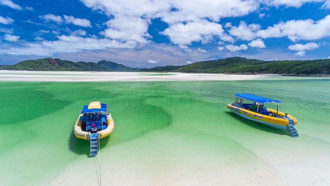 Two yellow rafts on clear green water at Whitehaven Beach, Whitsundays.