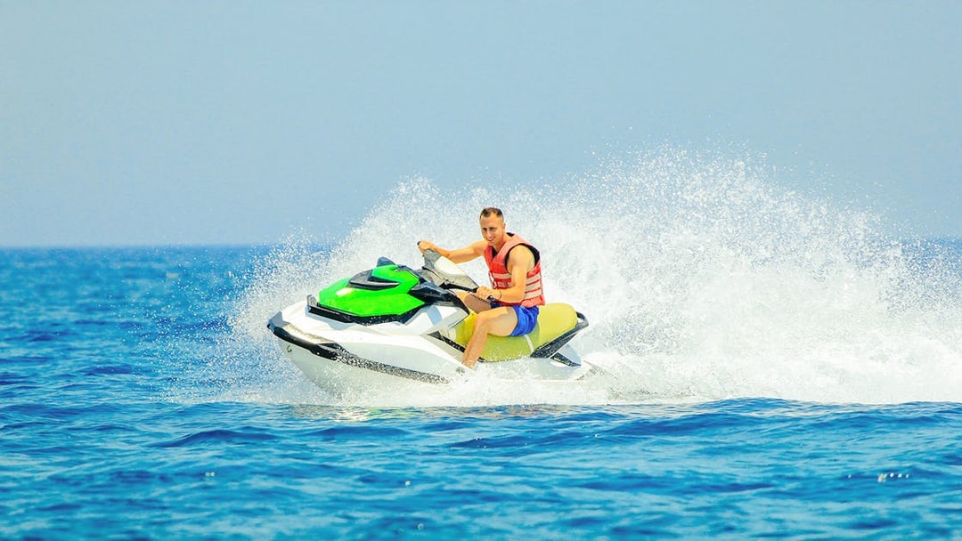 Tourist riding a jetski on open water.