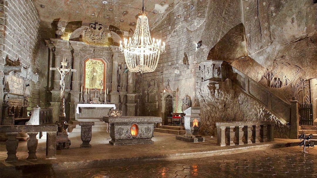 Wieliczka Salt Mine chapel interior with altar, chandelier, and carved salt walls.