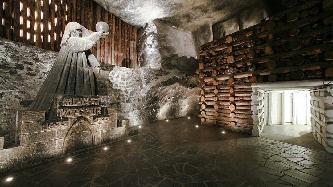 Wieliczka Salt Mine sculpture of a robed figure holding a sphere, surrounded by salt walls.