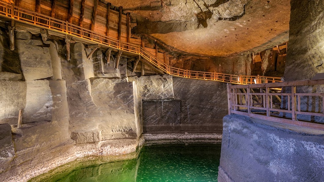 Wieliczka Salt Mine chamber with wooden walkways and illuminated salt formations, Krakow tour.