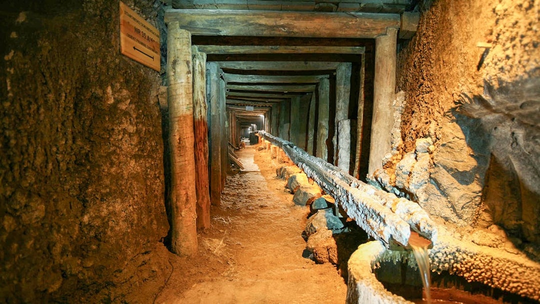 Wieliczka Salt Mine tunnel with wooden supports and brine flow, Krakow tour.