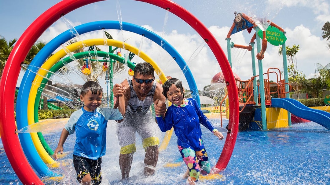Children and adult enjoying water play area at Wild Wild Wet, Singapore, part of Go City Pass.