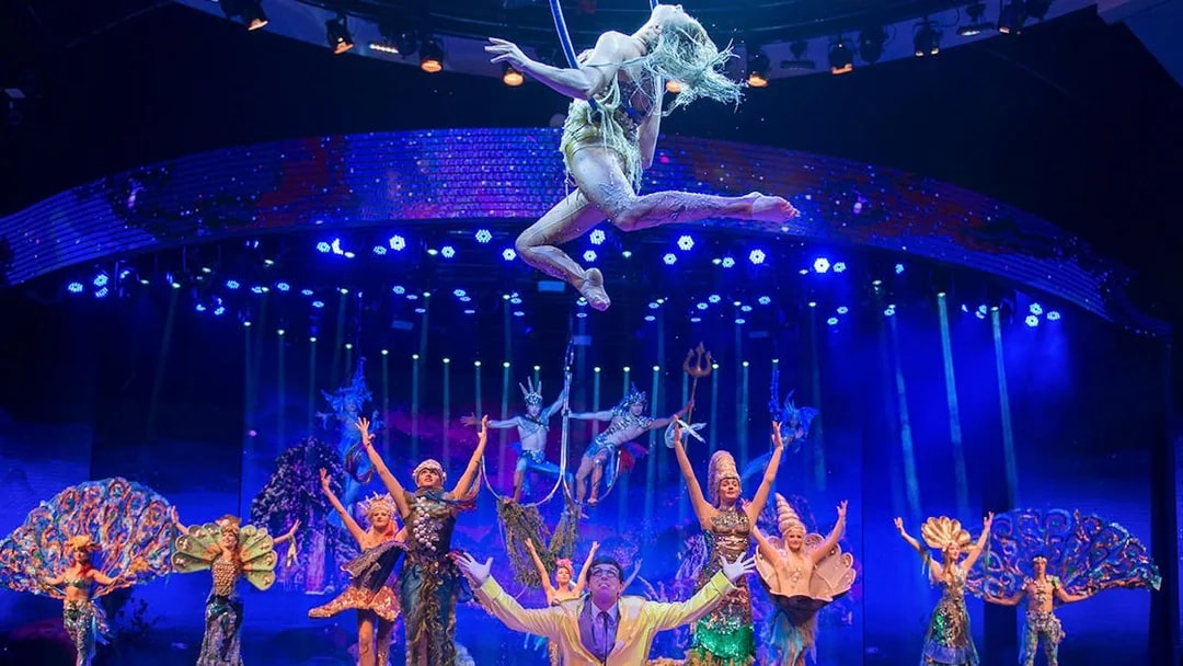 Acrobats performing in WOW: The Vegas Spectacular with vibrant costumes and stage lighting.