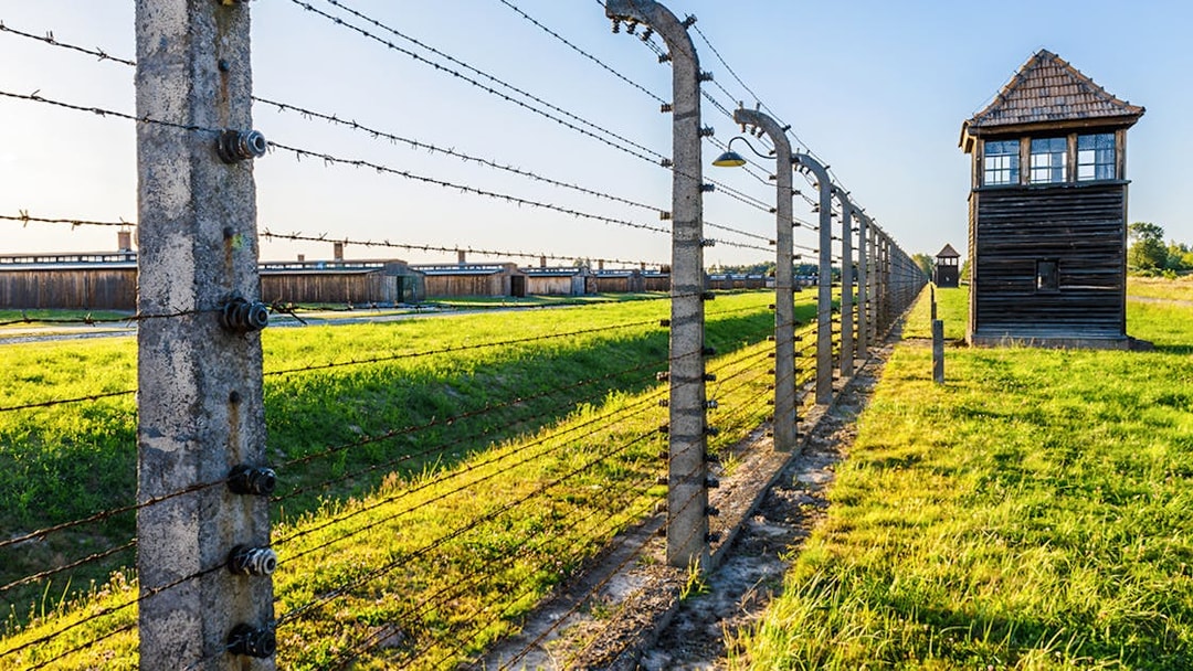 Barbed wire fence and watchtower at Auschwitz Birkenau, Auschwitz II barracks in Poland.