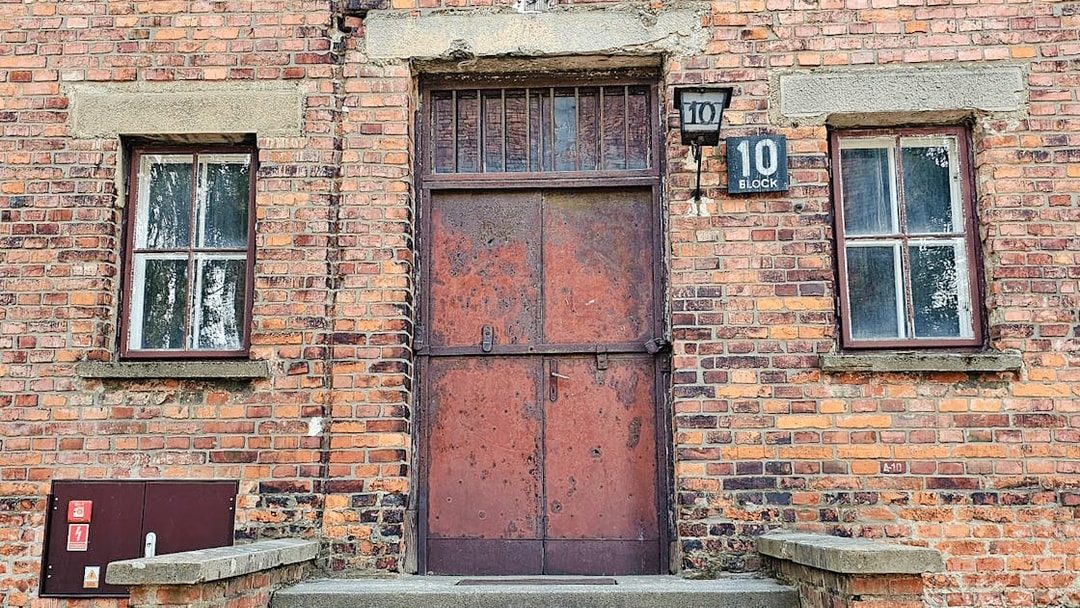 Barracks entrance at Auschwitz I, Block 10, with brick facade and metal door.