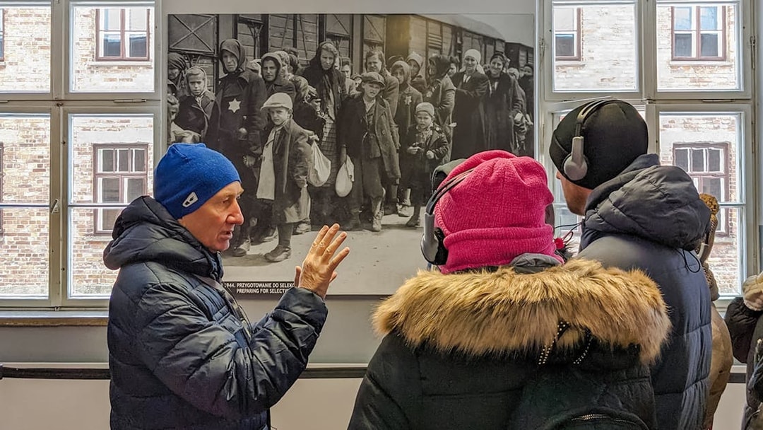Guide explaining historical photo during Auschwitz Birkenau tour from Wroclaw.