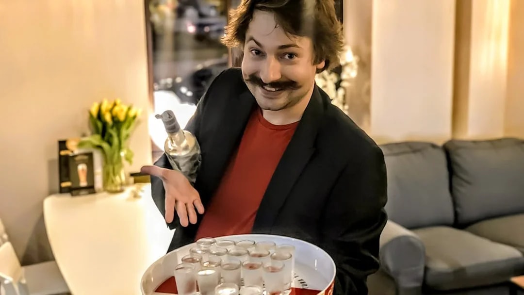 Man presenting vodka shots on a tray during a tasting event in Wroclaw.