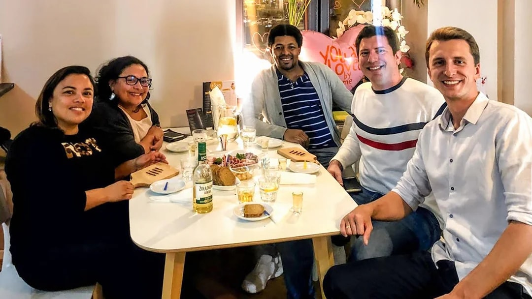 Group enjoying vodka tasting experience in Wroclaw with snacks and drinks on the table.