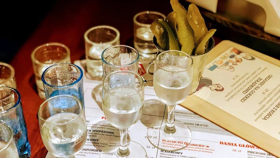 Vodka glasses and pickles on a table during a tasting tour in Wroclaw.