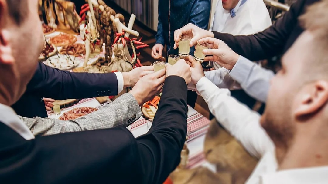 People toasting with vodka shots at a tasting event in Wroclaw.