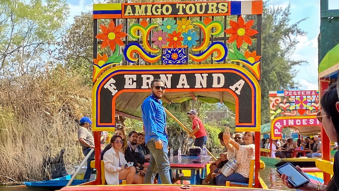 Trajinera boat with tourists on Xochimilco canal, Mexico City.