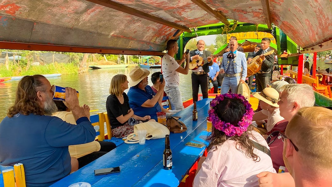 Guests enjoying live music on a Trajinera party boat in Xochimilco, Mexico.
