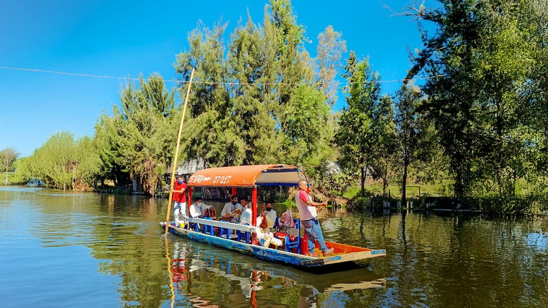 Trajinera boat with people on Xochimilco river, Mexico City.