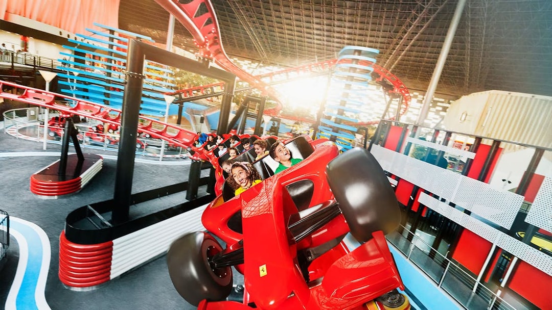 Roller coaster ride at Ferrari World, Yas Island, Abu Dhabi, with visitors enjoying the thrill.
