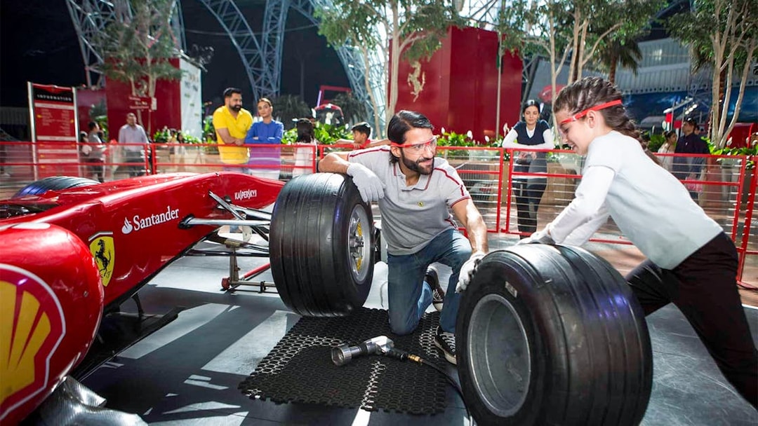Visitors changing tires on a Formula 1 car at Ferrari World, Yas Island, Abu Dhabi.