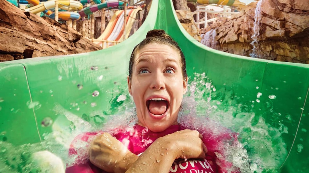 Person enjoying a water slide at Yas Waterworld, Abu Dhabi.