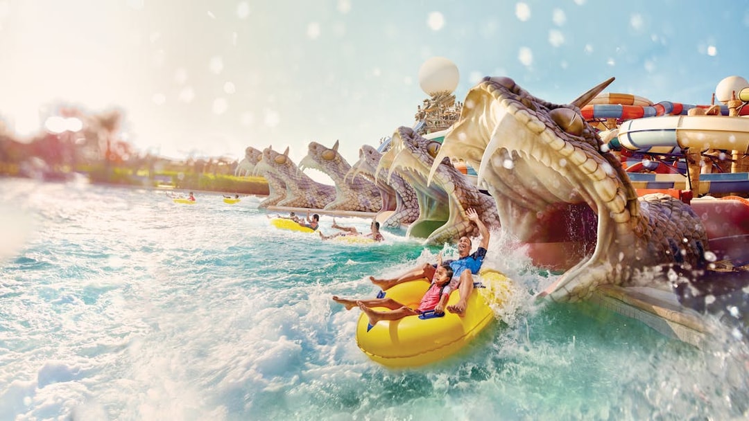 Visitors enjoying Slithers Slides at YAS Water Park, Abu Dhabi, on a yellow raft.
