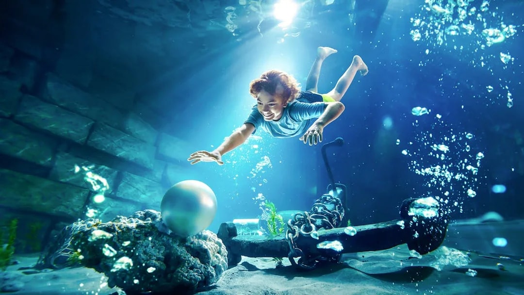 Young boy diving underwater for pearl at YAS Waterworld, Abu Dhabi.
