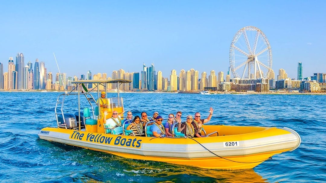 Speedboat tour in Dubai Marina with city skyline and Ferris wheel in background.