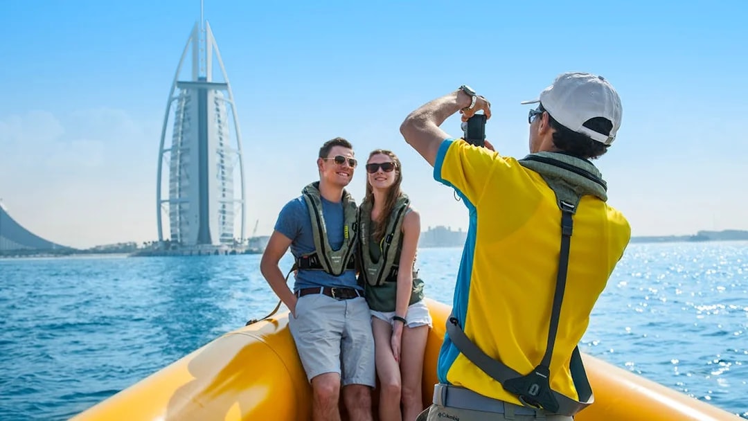 Couple on a speedboat tour in Dubai with Burj Al Arab in the background.