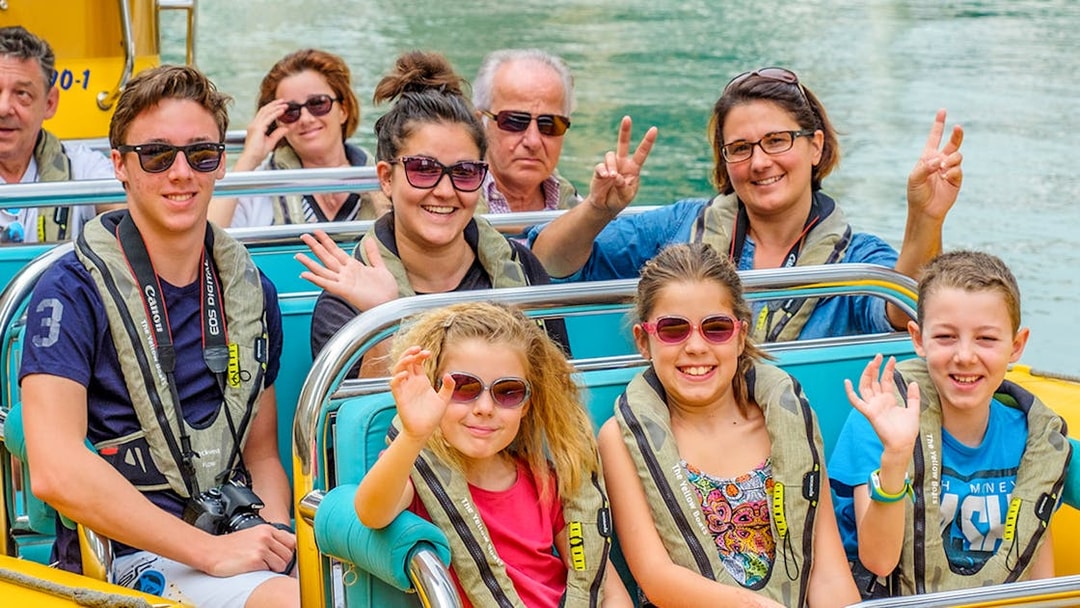 People smiling and waving on a Yellow Boats tour in Dubai.
