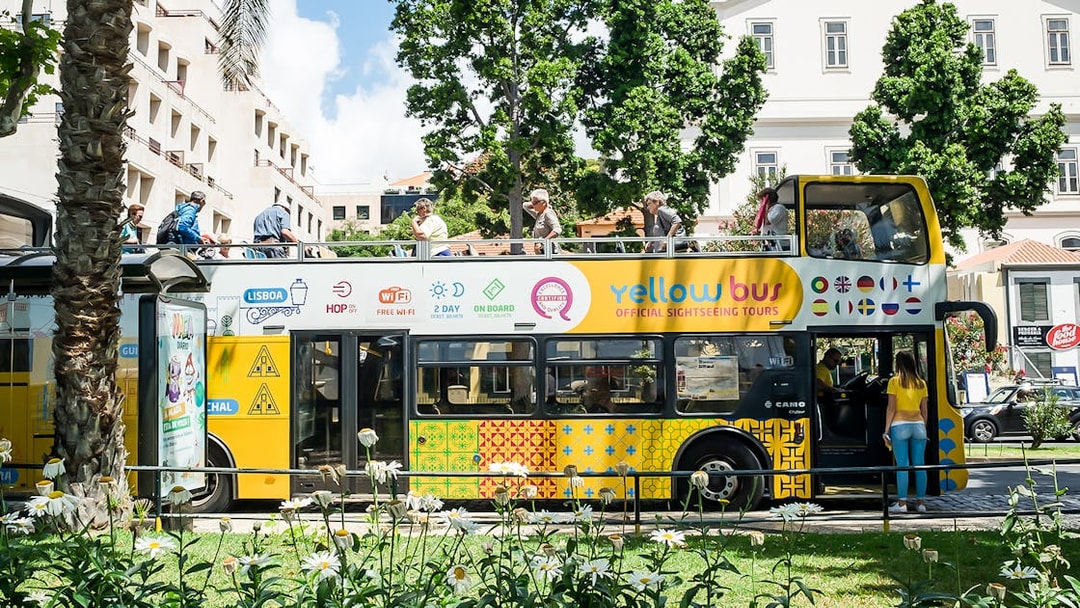 Open-top sightseeing bus in Madeira with tourists on board.