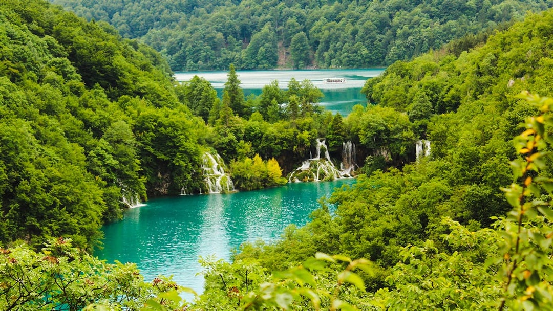 Waterfalls and turquoise lakes surrounded by lush greenery at Plitvice Lakes National Park, Croatia.