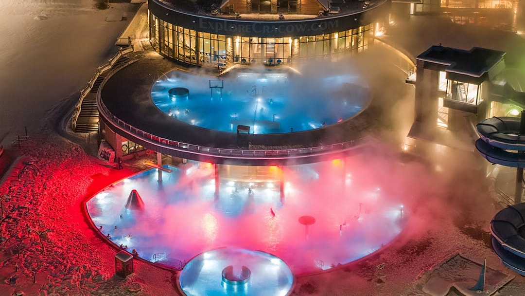 Tourists enjoying Chochołow Thermal Baths with colorful lights, Zakopane transfer included.