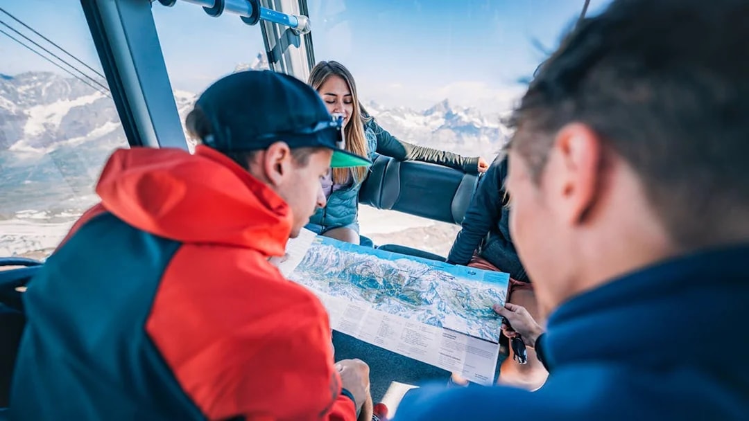 Tourists studying a map inside a cable car during the Matterhorn Glacier Paradise excursion.