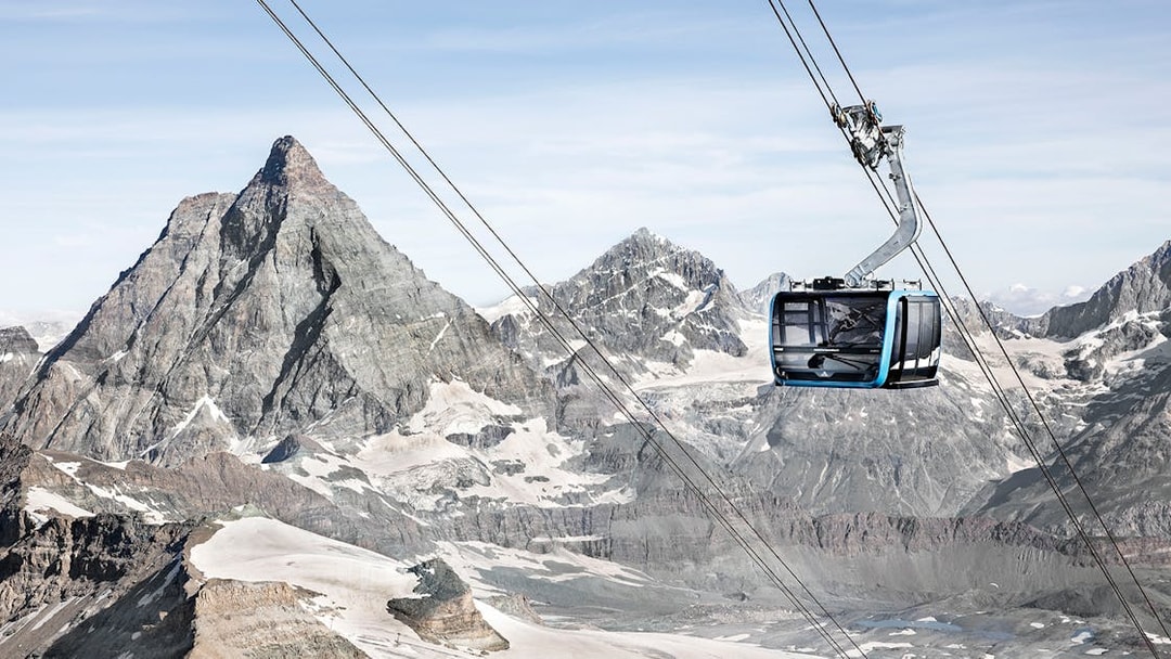 Zermatt cable car ascending towards Matterhorn Glacier Paradise with snow-covered peaks.
