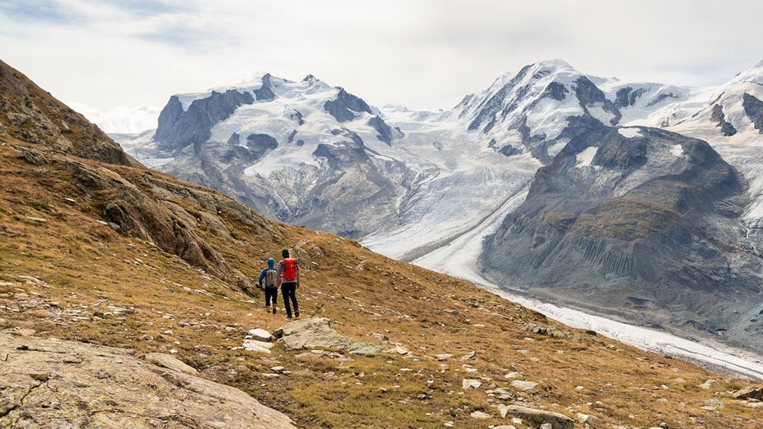 Visitors hiking towards Gornergrat viewing platform with snowy mountains in the background.