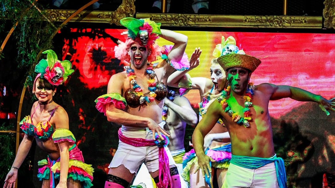 Performers in colorful costumes on stage during Zombie Burlesque show.