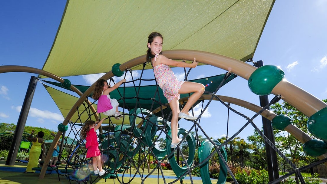 Children climbing a rope structure at Zoo Miami playground.